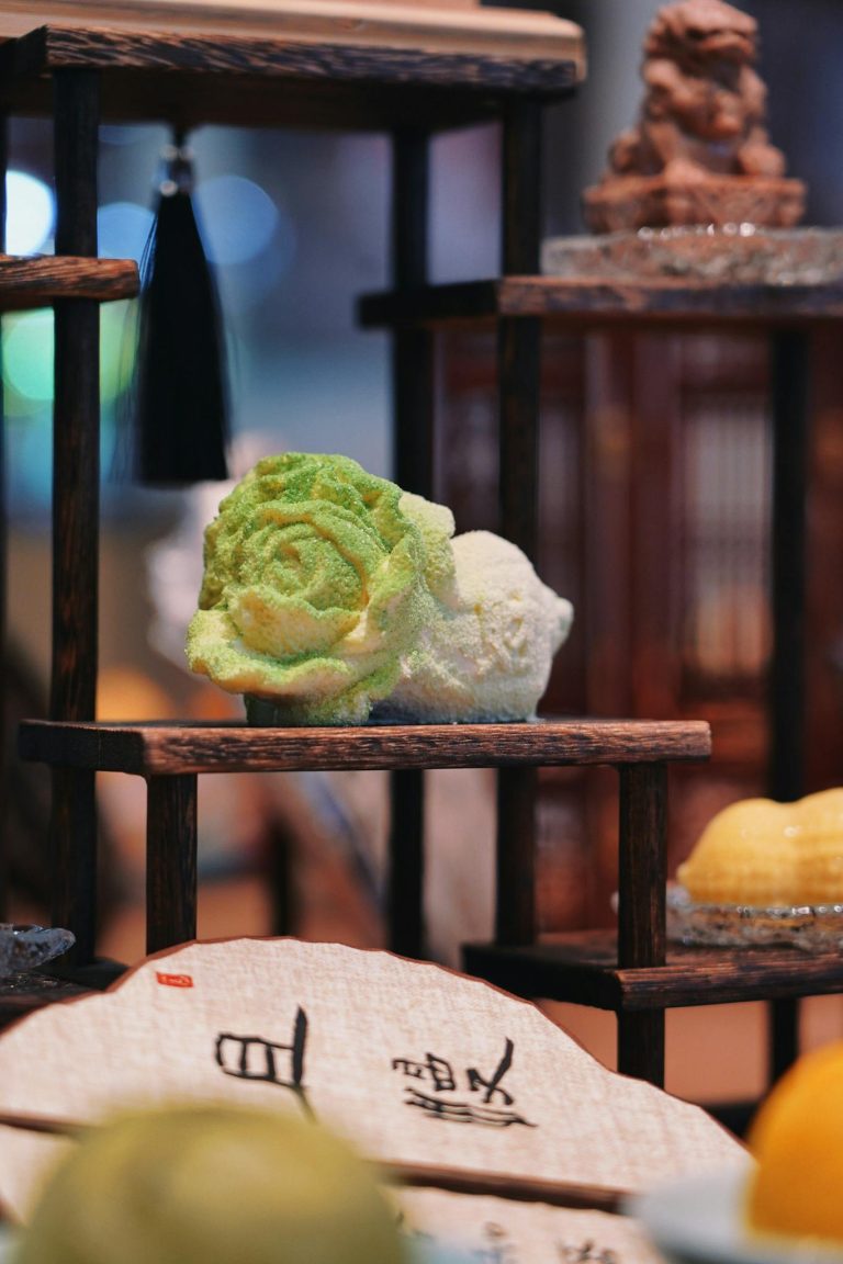 Intricate wooden shelves displaying Asian decor with a focus on a green jade sculpture.